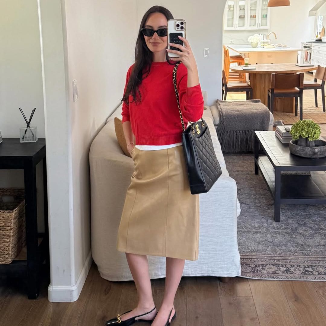 Κοπέλα που φοράει khaki μίντι φούστα με κόκκινο πουλόβερ.