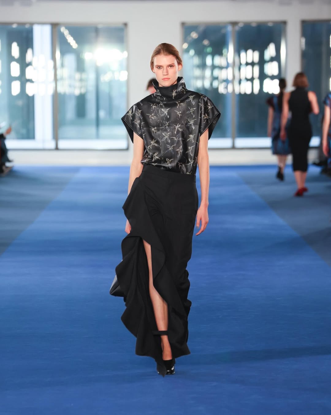 Look από την πασαρέλα της Proenza Schouler για fall26 με δερμάτινο τοπ με funnel neck λαιμόκοψη. 