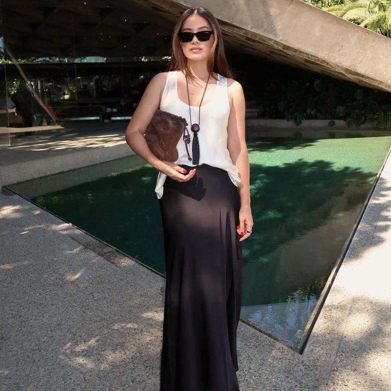 Koπέλα που φοράει μάξι σατέν φούστα με λευκό φανελάκι.