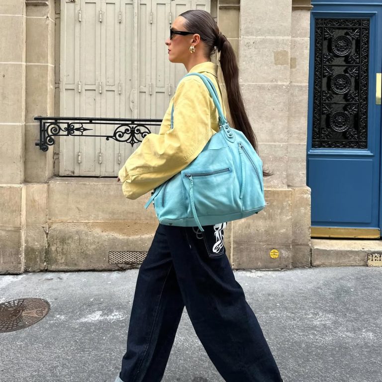 Κοπέλα που κρατάει τιρκουάζ τσάντα.