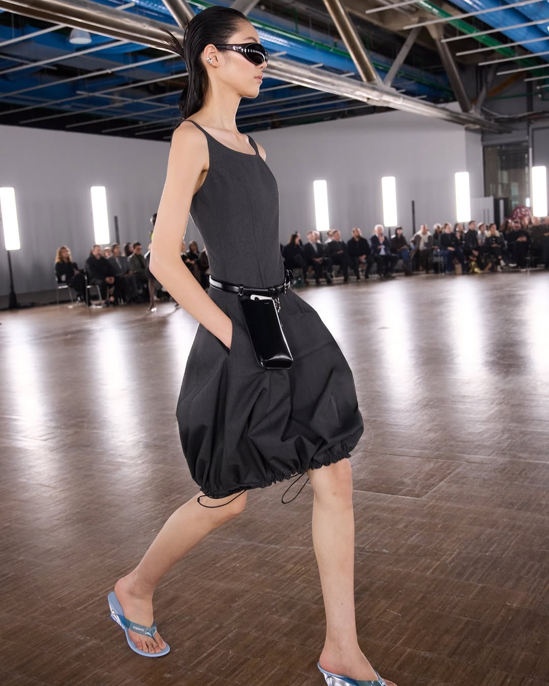 Look από την ανοιξιάτικη συλλογή της Coperni με total black σύνολο και γυαλιά ηλίου squoval που είναι τάση.