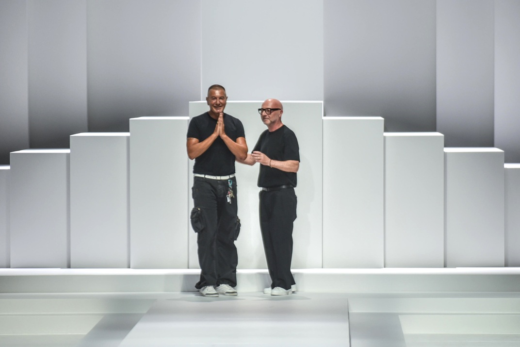 Oι Domenico Dolce (δεξιά) και ο Stefano Gabbana (αριστερά) χαιρετούν το κοινό μετά την παρουσίαση της κολεξιόν Dolce & Gabbana Menswear Ready-to-wear Spring-Summer 2026 στο πλαίσιο της Εβδομάδας Μόδας στο Μιλάνο, 21 Ιουνίου 2025