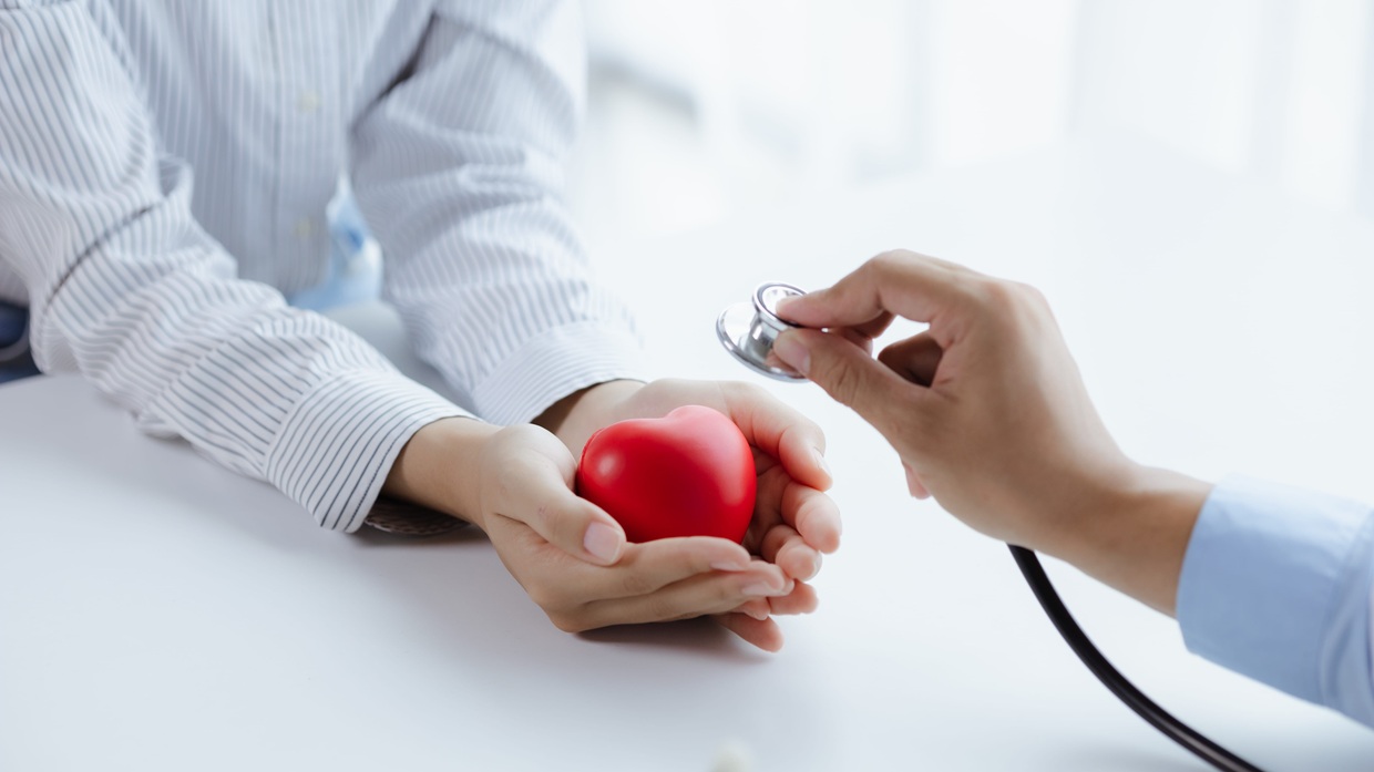 Ένας γιατρός χρησιμοποιεί ένα στηθοσκόπιο, ενώ ο ασθενής κρατάει μια ψεύτικη καρδιά στο χέρι, εξετάζοντας την πάθηση από ιατρική άποψη και παρέχοντας θεραπεία επί τόπου