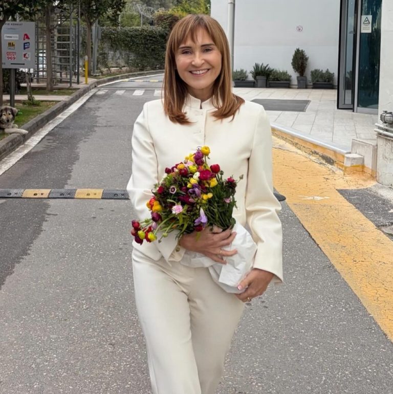 Η Μάρα Ζαχαρέα με λευκό σύνολο και λουλούδια στα χέρια