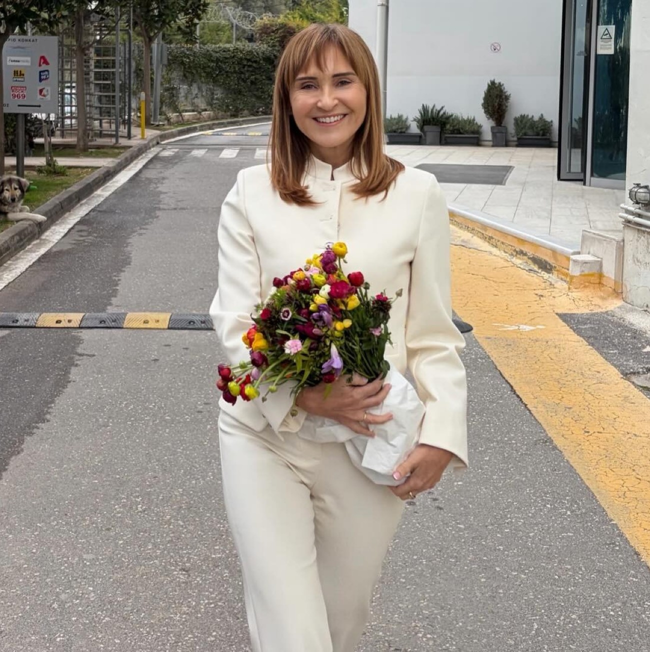 Η Μάρα Ζαχαρέα με λευκό σύνολο και λουλούδια στα χέρια