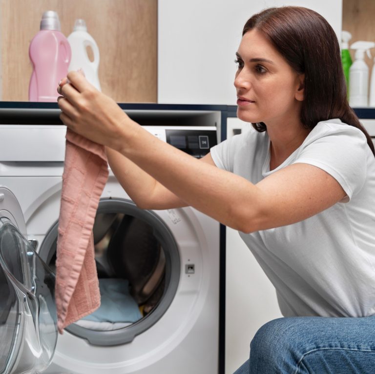 Γυναίκα κοιτάζει τα ρούχα που πλύθηκαν στο πλυντήριο.