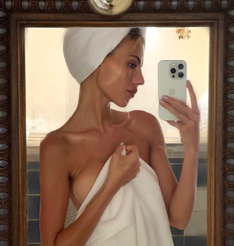 Γυναίκα μπροστά σε καθρέφτη παίρνει σέλφι. Το θέμα μας πότε πρέπει να κάνουμε ντους... πρωί ή βράδυ;