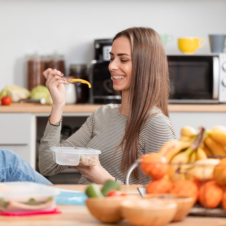 Γυναίκα τρώει μέσα από πλαστικό τάπερ