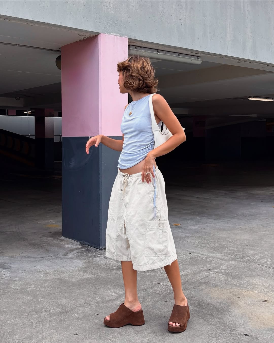 Γυναικείες καφέ σουέτ πλατφόρμες slingback με άνοιγμα στα δάχτυλα, συνδυασμένες με off-white βερμούδα και γαλάζιο τοπ σε casual καλοκαιρινό στιλ.
