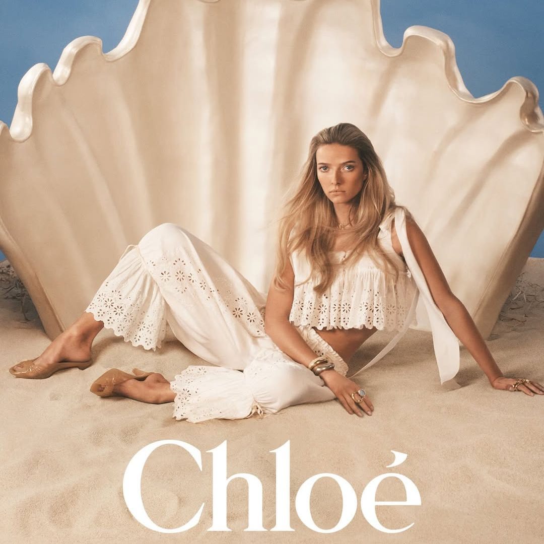Η Apple Martin στην καμπάνια "à la Plage" του οίκου Chloé για το καλοκαίρι 2026, φορώντας λευκό eyelet σετ.