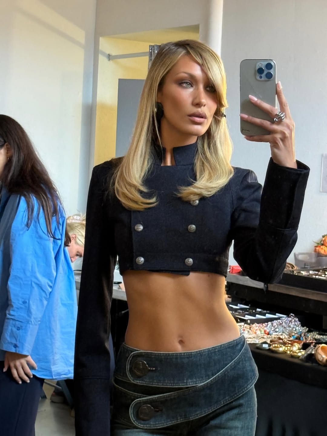 H Bella Hadid με ultra-cropped μαύρο military τζάκετ με ψηλό γιακά και χαμηλοκάβαλη τζιν φούστα.