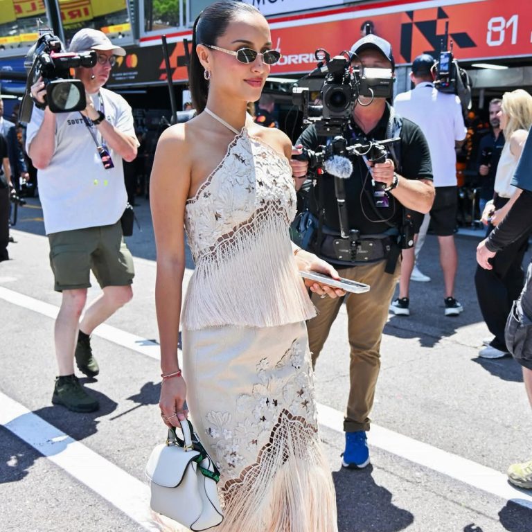 Η Alexandra Leclerc στο 2026 Monaco Grand Prix με λευκό Oscar de la Renta φόρεμα με κρόσσια και ivory Mini Poppy τσάντα.