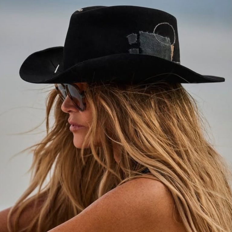 Η Elle Macpherson με μαύρο καουμπόικο καπέλο Bam Bam Hats με denim patchwork λεπτομέρειες και καφέ aviator γυαλιά ηλίου.