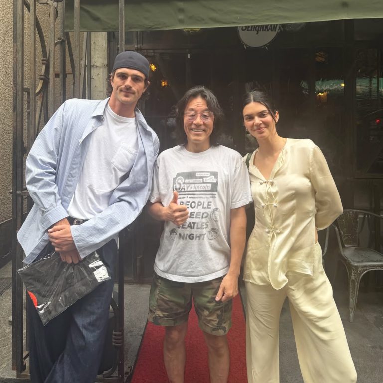 Η Kendall Jenner με ivory pajama matching σετ και olive green τσάντα The Row, δίπλα στον Jacob Elordi που φοράει ριγέ πουκάμισο, λευκό t-shirt και τζιν στο Τόκιο.