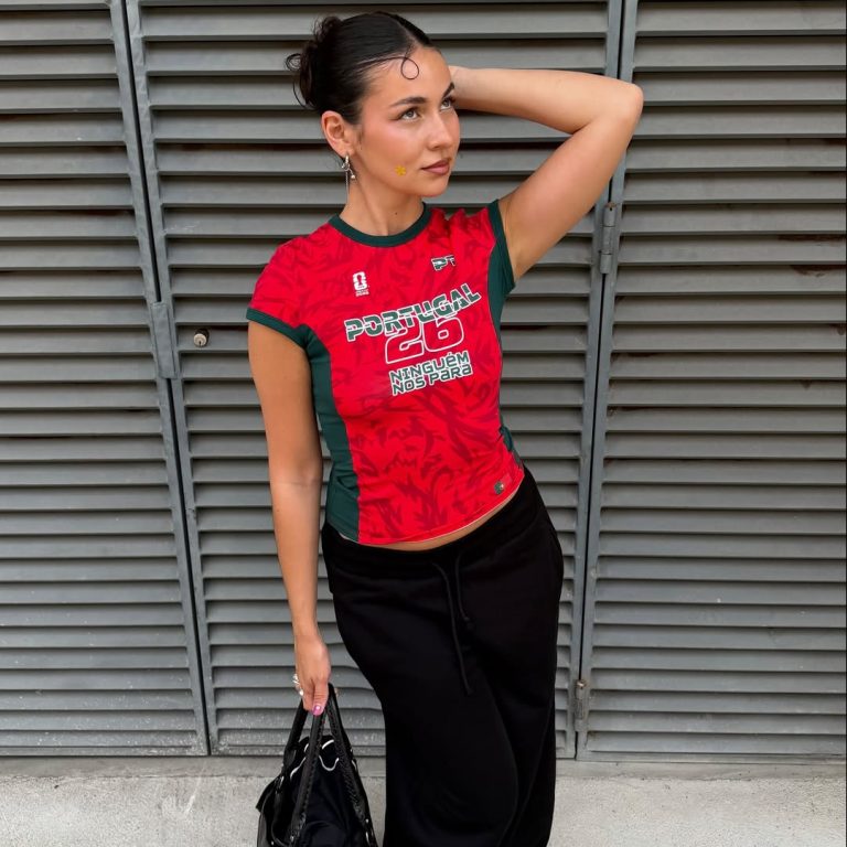 Κοπέλα που φοράει κόκκινο ποδοσφαιρικό t-shirt με μάξι μαύρη φούστα.