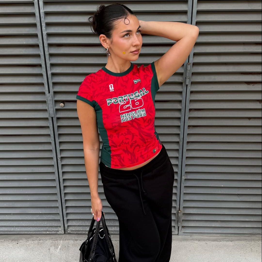 Κοπέλα που φοράει κόκκινο ποδοσφαιρικό t-shirt με μάξι μαύρη φούστα.