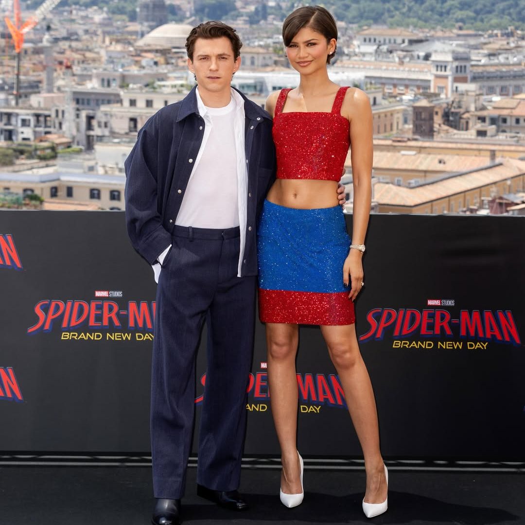Zendaya με κόκκινο και μπλε vintage Versace σύνολο δίπλα στον Tom Holland με navy τζάκετ στο press tour του Spider-Man στη Ρώμη