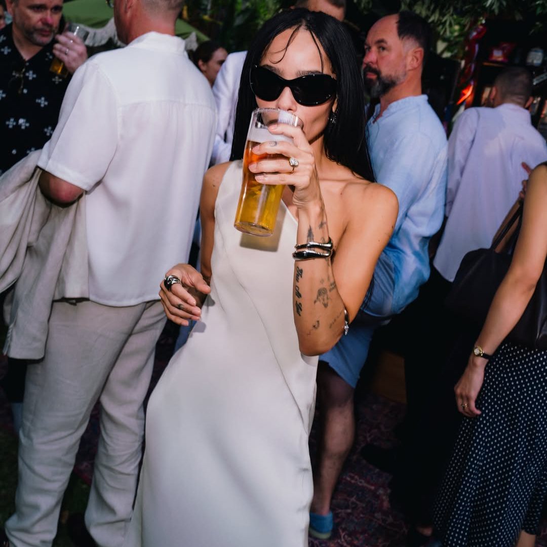 Η Zoë Kravitz με bridal λευκό έξωμο φόρεμα, oversized γυαλιά ηλίου και το 9 καρατίων μονόπετρο δαχτυλίδι αρραβώνων της από τον Harry Styles.