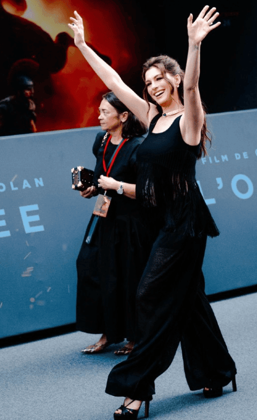 Η Anne Hathaway σε εμφάνιση με μαύρη παντελόνα και μπαντό τοπ με κρόσσια, ένα ιδανικό κομψό look για εγκύους.