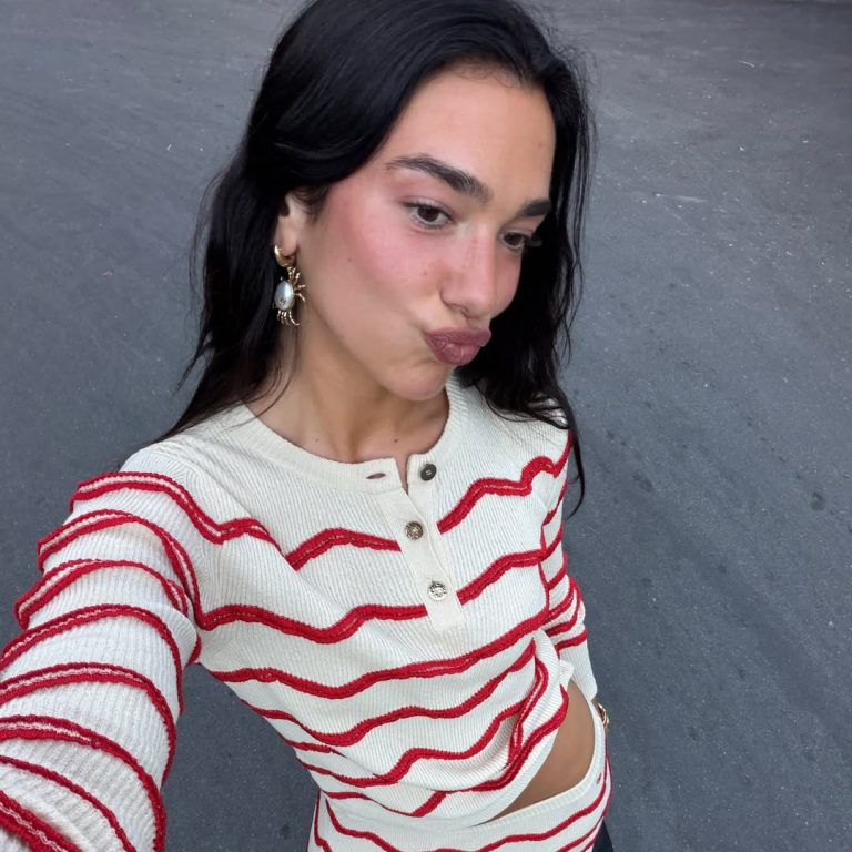 Dua Lipa με λευκό πλεκτό σετ με κόκκινες ρίγες.