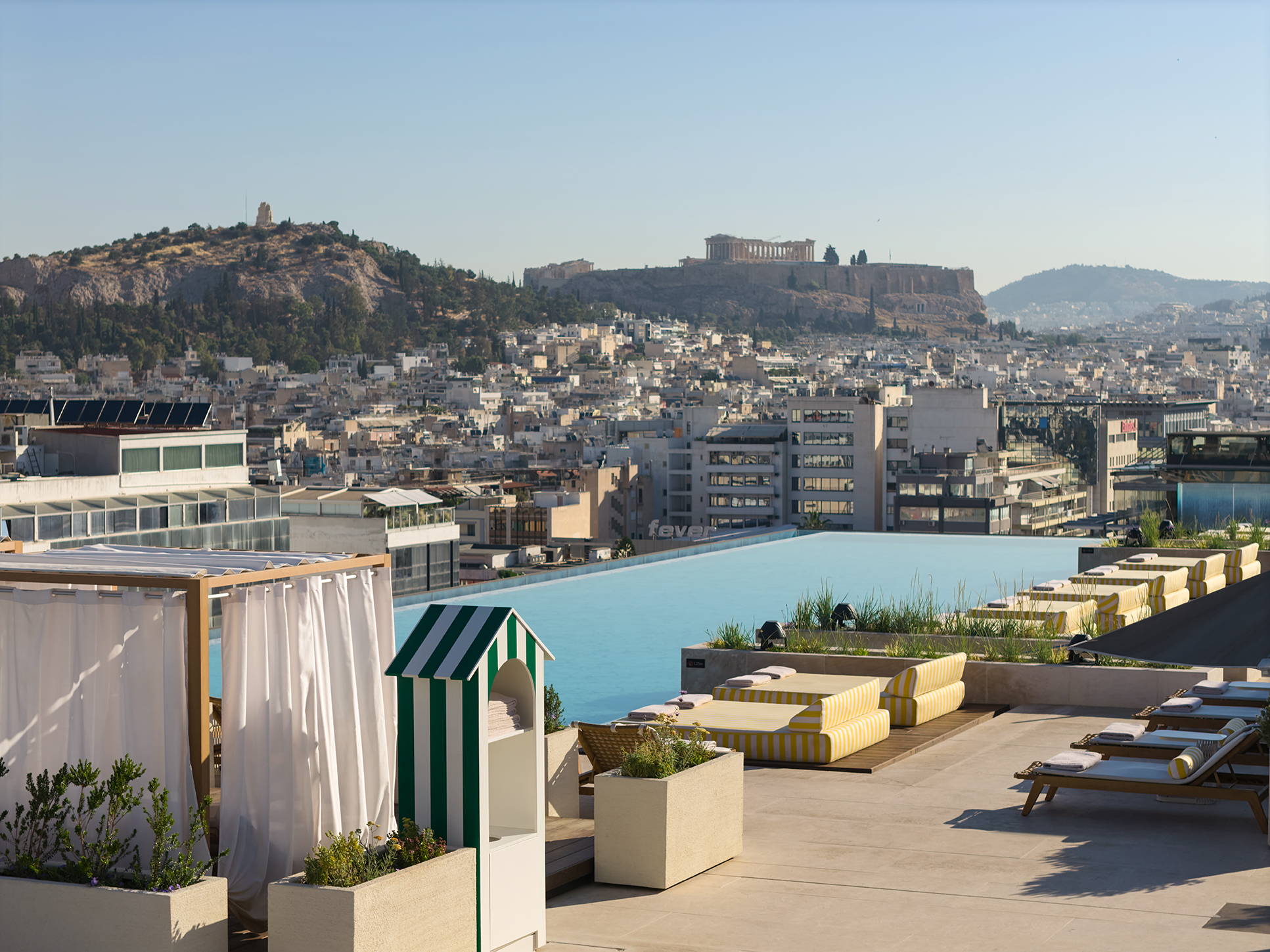 Επισκέπτες απολαμβάνουν την rooftop πισίνα του Grand Hyatt Athens με θέα την Ακρόπολη