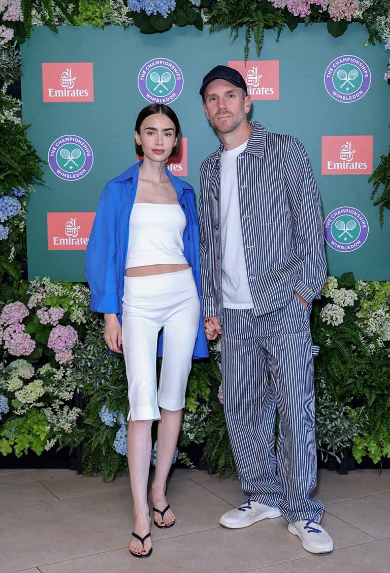 H Lily Collins με λευκό σύνολο και μπλε πουκάμισο στο Wimbledon. Μαζί της και ο Charlie McDowell στο All England Lawn Tennis and Croquet Club στις 12 Ιουλίου 2026 στο Λονδίνο.