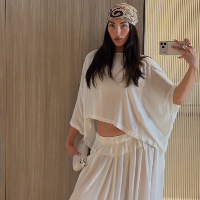 Γυναίκα με λευκό oversized σύνολο και εμπριμέ μαντίλι.