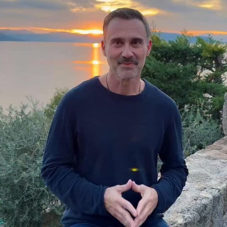 Ο Γιώργος Καπουτζίδης με φόντο τη θάλασσα και το ηλιοβασίλεμα