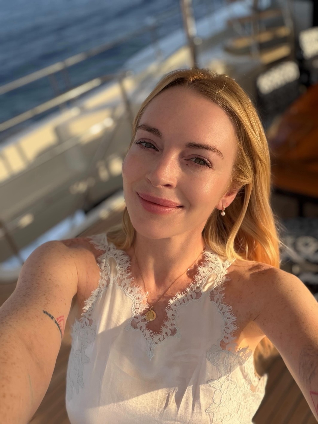H Lindsay Lohan με λευκό φόρεμα, σε λινή εκδοχή και halter λαιμόκοψη. Με δαντέλα στις τιράντες και κάτω από τα μπράτσα για μια πιο ρομαντική διάσταση και για τελική υπογραφή ένα χρυσό κολιέ.