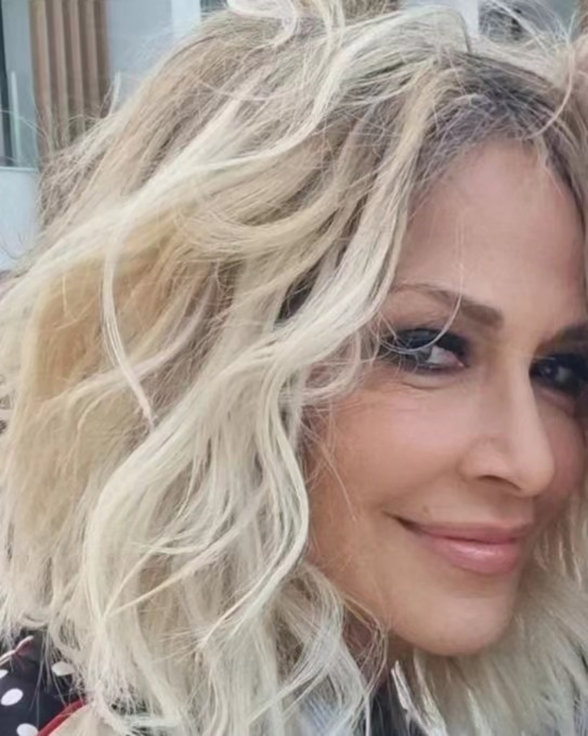 Πορτρέτο της Άννας Βίσση να χαμογελά πονηρά.