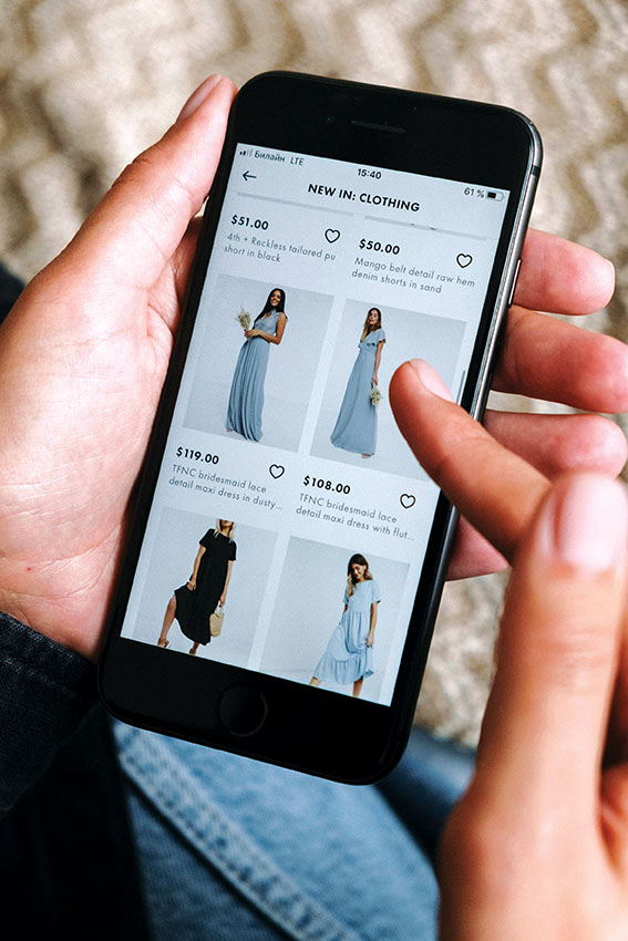 Γυναίκα που ψάχνει σε app να ψωνίσει vintage ρούχα- Vinted resale fashion trends