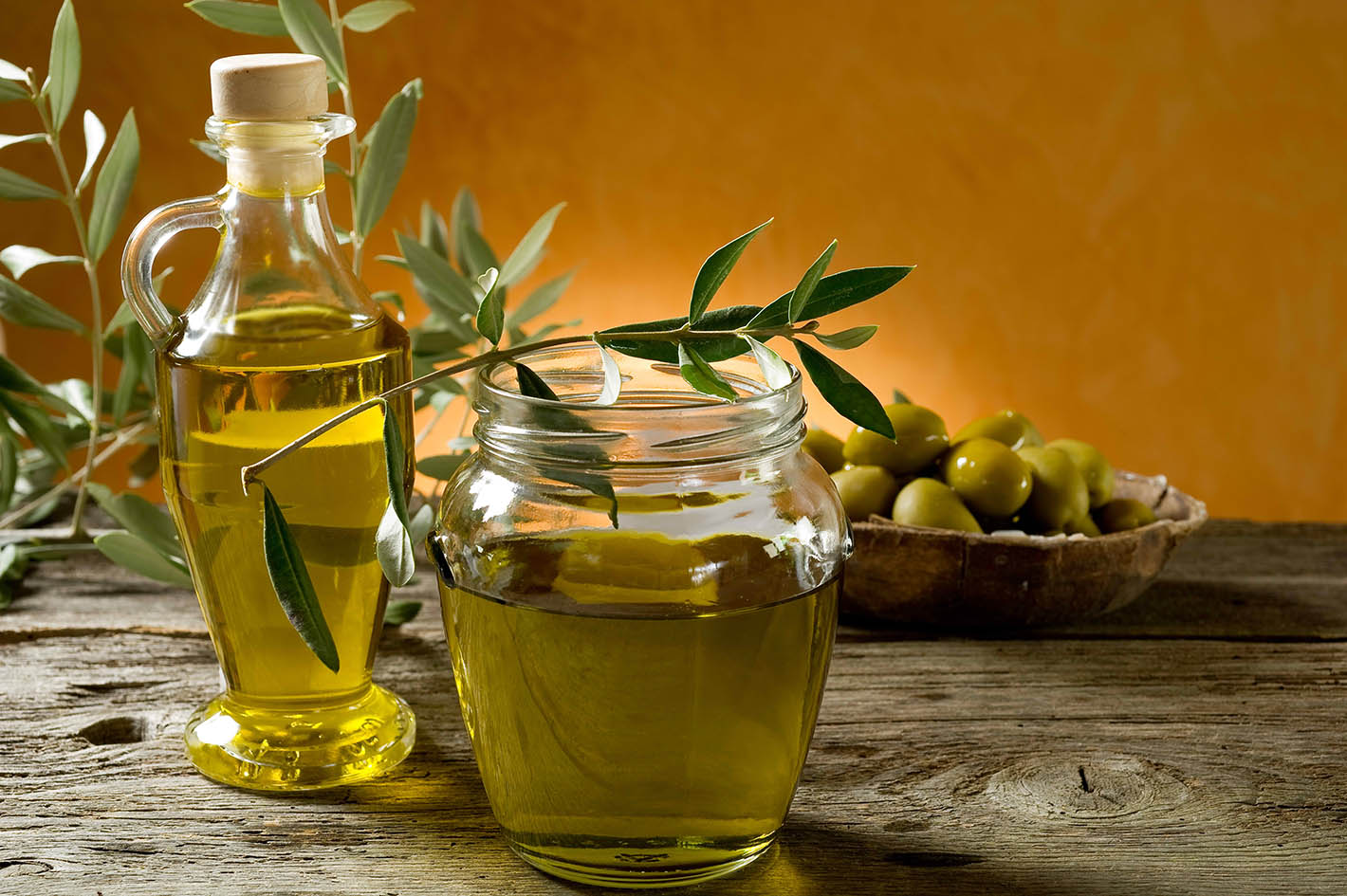 Ελαιόλαδο σε μπουκάλια και κλαδί ελιάς.