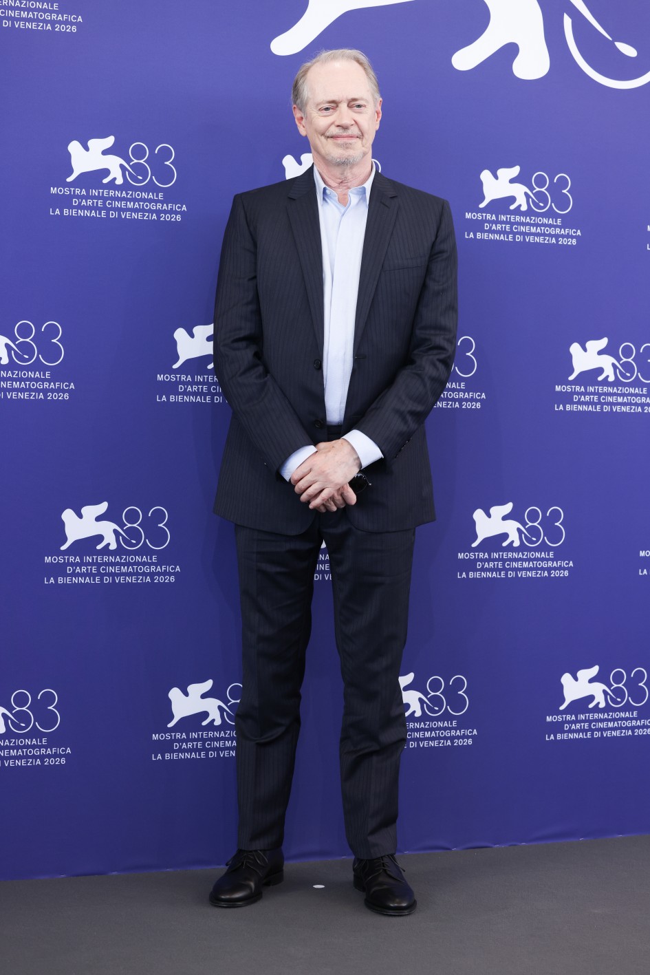 Ο Steve Buscemi με ένα κοστούμι Dior με λεπτή ρίγα σε σκούρα απόχρωση, ένα ανοιχτό γαλάζιο βαμβακερό πουκάμισο και ένα ζευγάρι μαύρα λουστρίνι ντέρμπι. Credit: Getty Images / File Dior