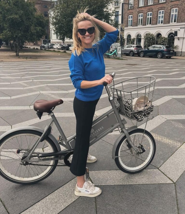 H Reese Whiterspoon χαμογελά στον φακό ενώ ετοιμάζεται για ποδηλατάδα.