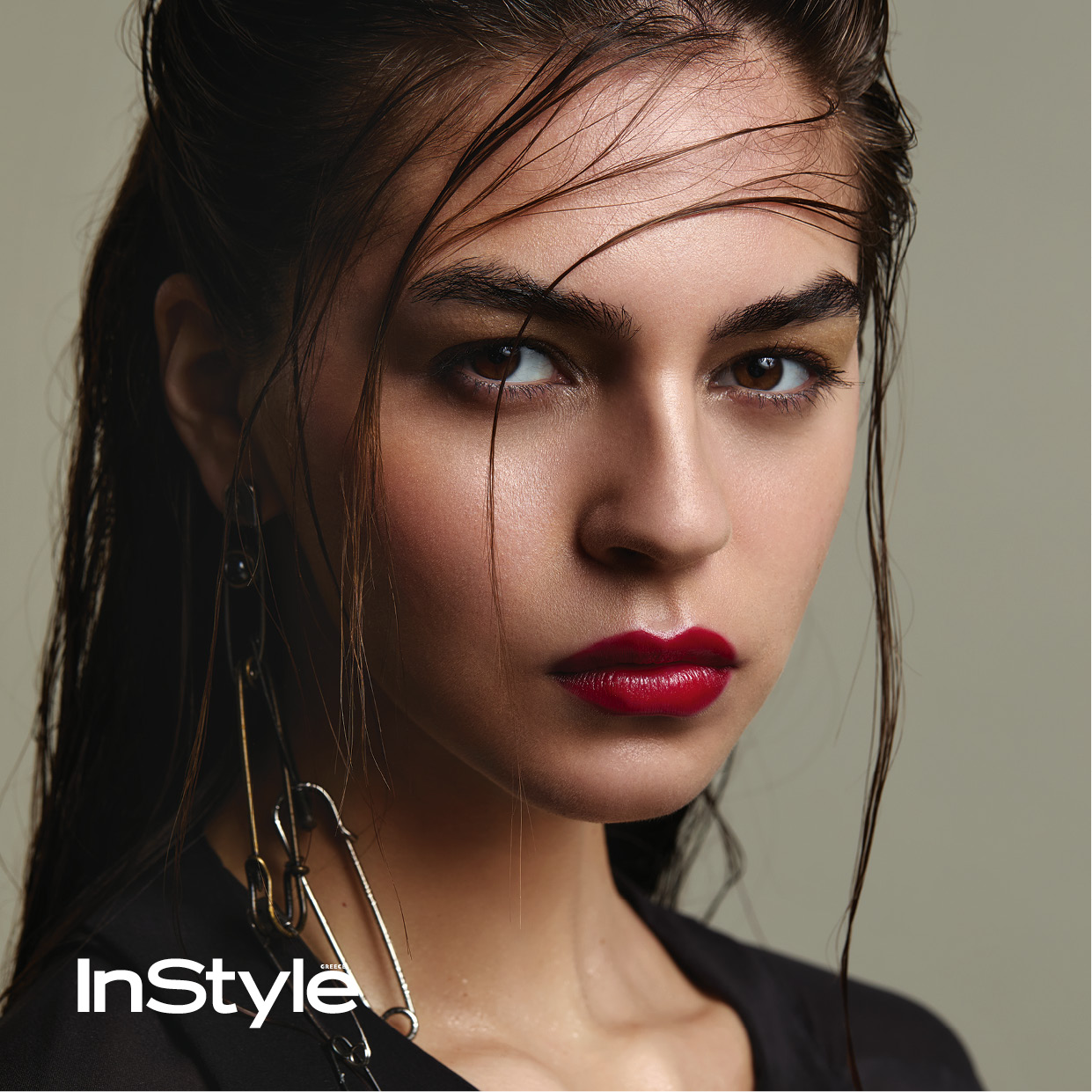 Beauty editorial του InStyle Greece με κοντινό πλάνο μοντέλου, κόκκινο κραγιόν, wet look μαλλιά και ιδιαίτερο σκουλαρίκι