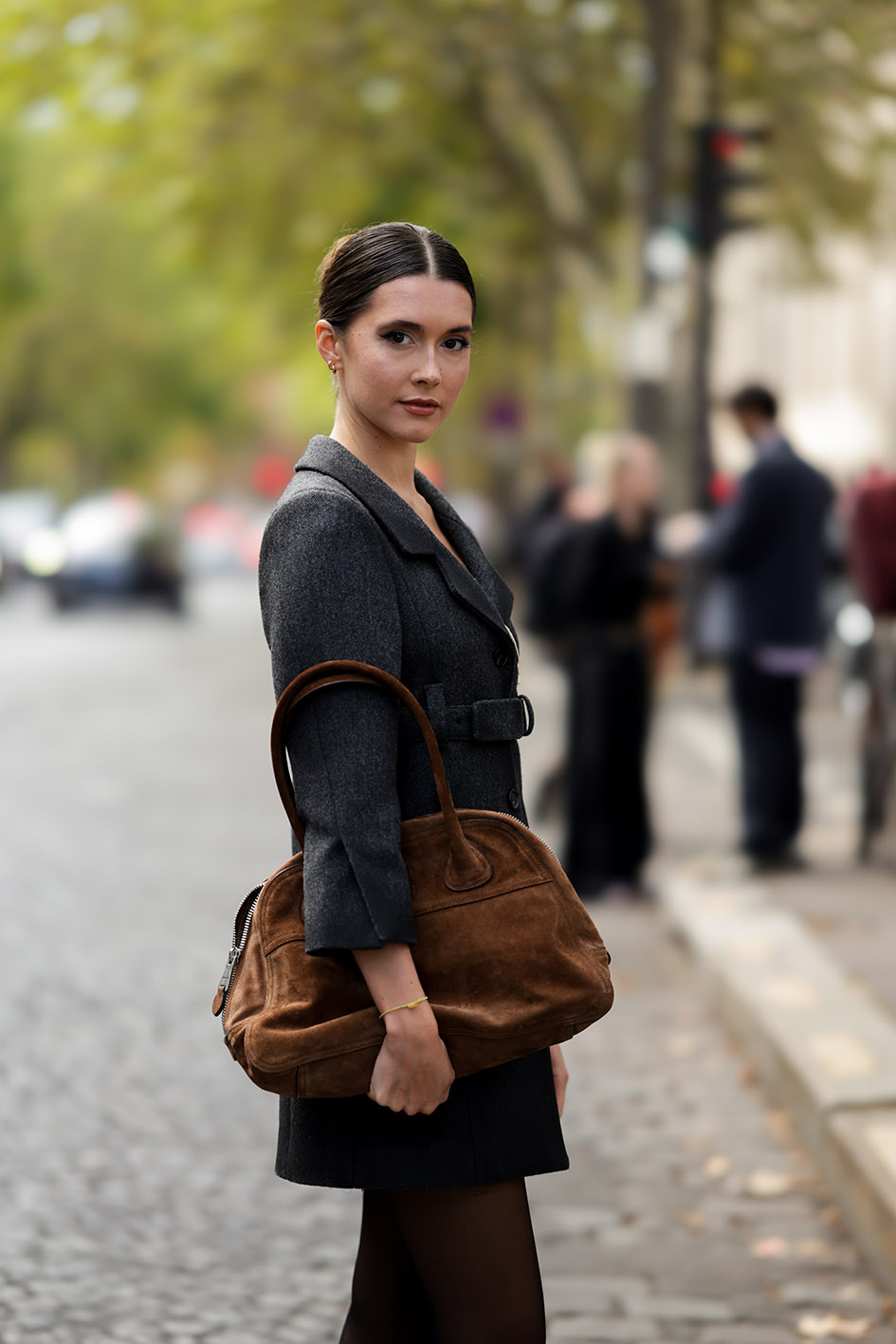 H Chiara King με μάλλινο παλτό σε γκρι ανθρακί με οδοντωτό πέτο και μια μίνι φούστα σε γκρι ανθρακί από τη Miu Miu. Μαζί της κρατά μια μεγάλη καφέ δερμάτινη σουέτ τσάντα Miu Miu Vivant. Συνόδευσε την εμφάνιση με χρυσά σκουλαρίκια, βραχιόλι και δαχτυλίδια, ενώ τα μαλλιά της τα είχε σε χαμηλό κότσο. Η φωτογραφία είναι από το σόου της Miu Miu κατά τη διάρκεια της έβδομης ημέρας της Εβδομάδας Μόδας στο Παρίσι.