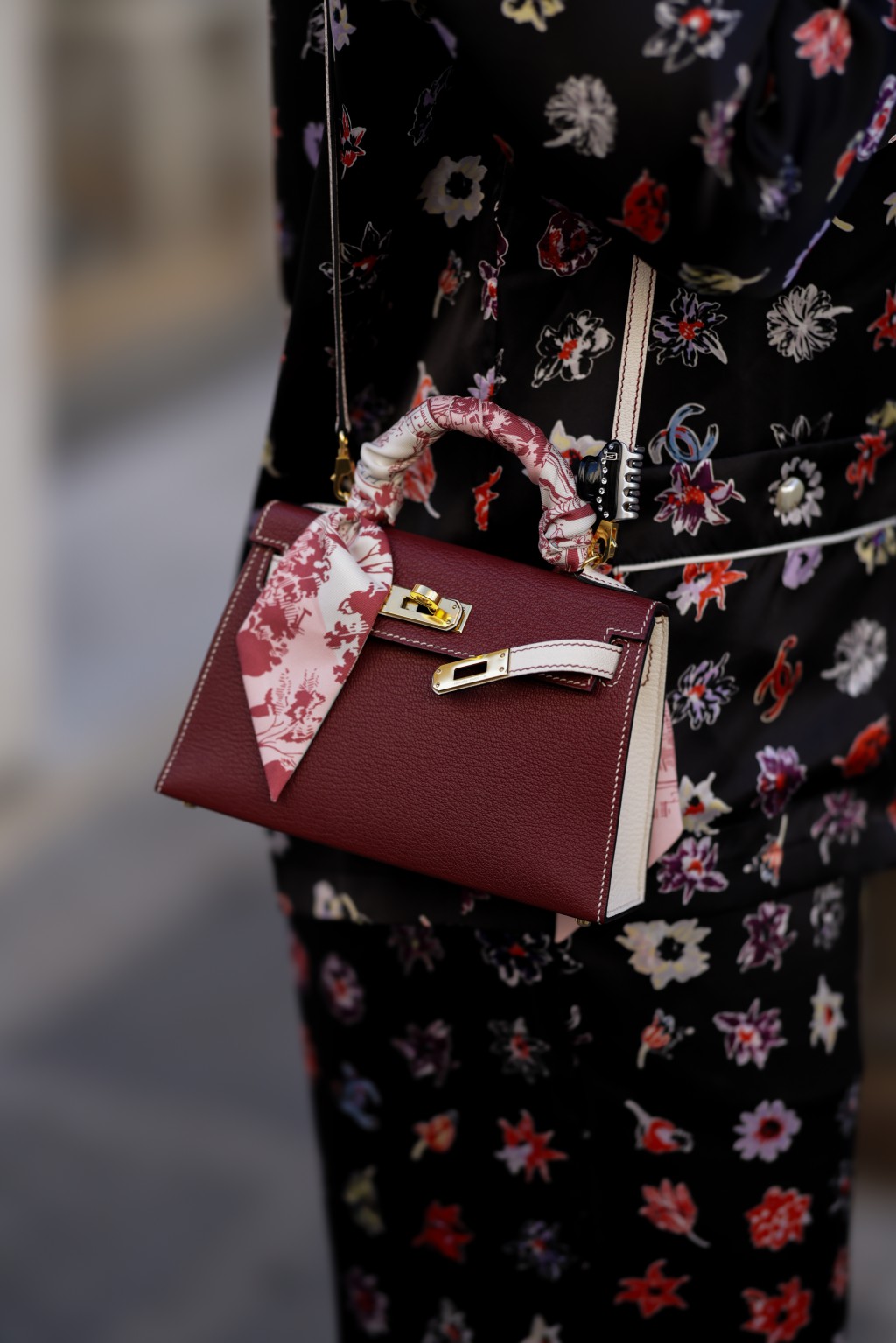 Kαλεσμένη με μπορντό δερμάτινη Hermès Kelly Mini τσάντα με λαβή και ροζ και κρεμ μεταξωτό κασκόλ Hermès Twilly δεμένο γύρω από το χερούλι της. Την Εβδομάδα Μόδας στο Παρίσι στις 6 Οκτωβρίου 2026.