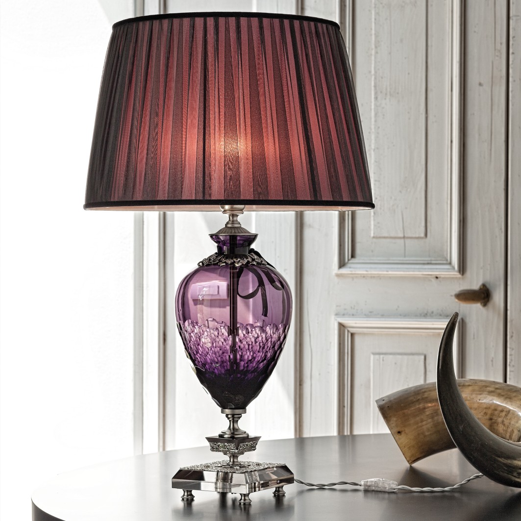 Το επιτραπέζιο φωτιστικό Large Amethyst Cut Glass Table Lamp της Juliettes Interiors συνδυάζει φυσητό γυαλί σε μωβ απόχρωση με περίτεχνες ανάγλυφες λεπτομέρειες και ασημένια βάση.