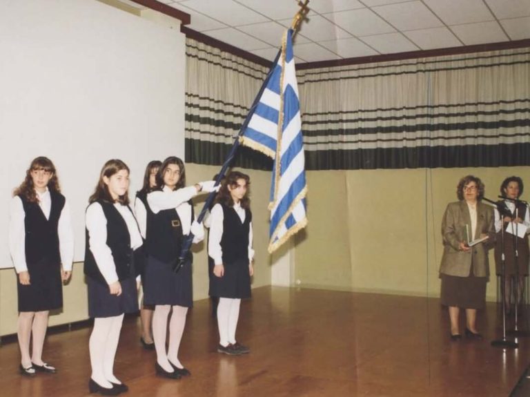 Σταματίνα Τσιμτσιλή σε παλιά φωτογραφία ανήμερα 28ης Οκτωβρίου με τη σημαία και τη στολή από τη σχολική γιορτή.