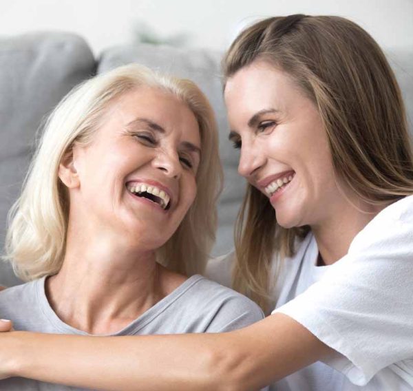 Mother and young daughter laughing having fun together at home