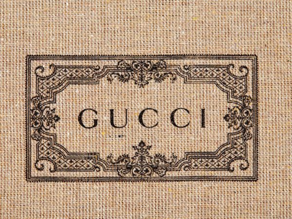 Gucci bar-Print impression with the GUCCI logo in black on a linen textile fabric. Belarus, Minsk, 25.03.2021. Horizontal image.