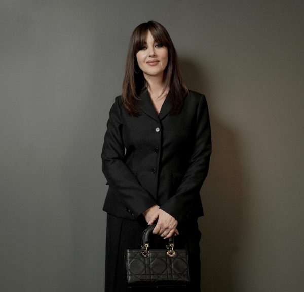 Η Monica Bellucci φόρεσε ένα μαύρο κοστούμι Dior και μια τσάντα Dior.