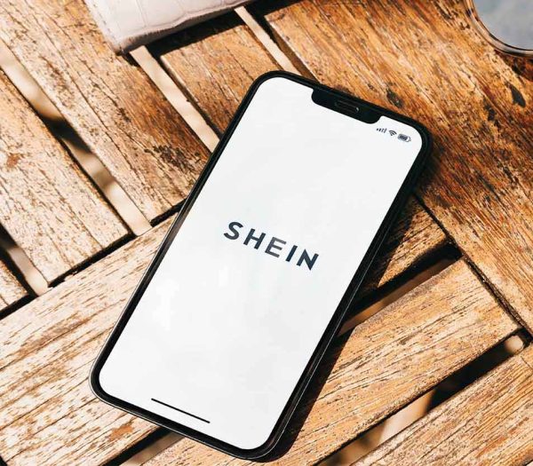 Shein online shopping app on the smartphone screen on the wooden