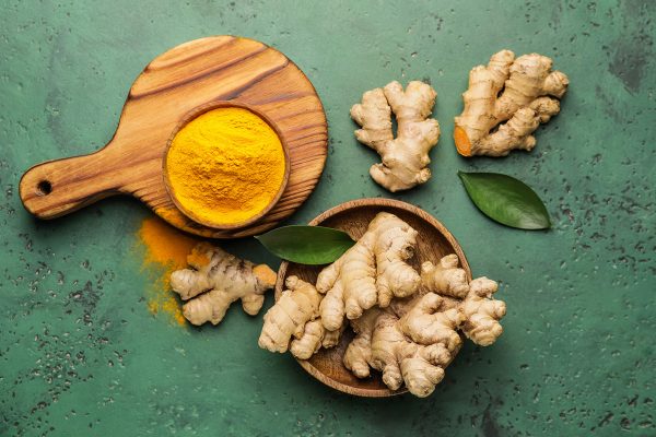 Composition with turmeric powder and roots on color background