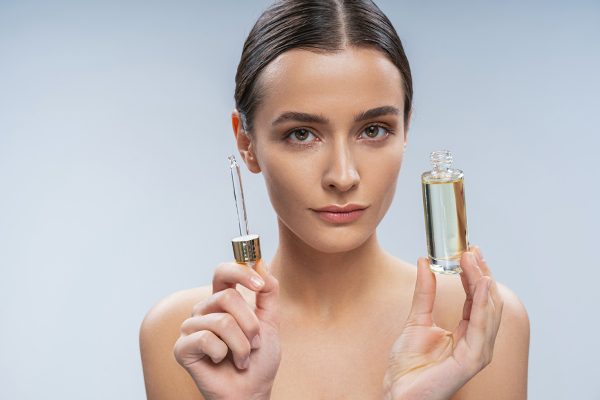 Young woman looking after skin with serum