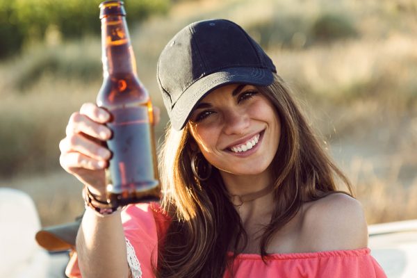 Beautiful young woman drinking beer and enjoying summer day.
