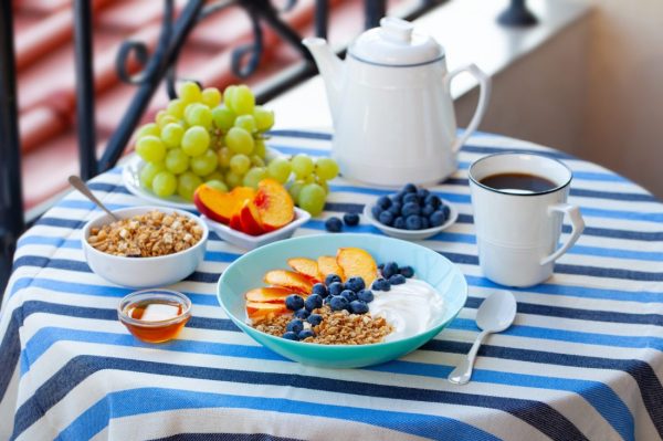 Healthy breakfast with coffee served on table. Outdoor background.
