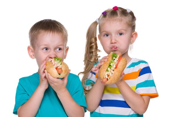 Children eat hot dogs