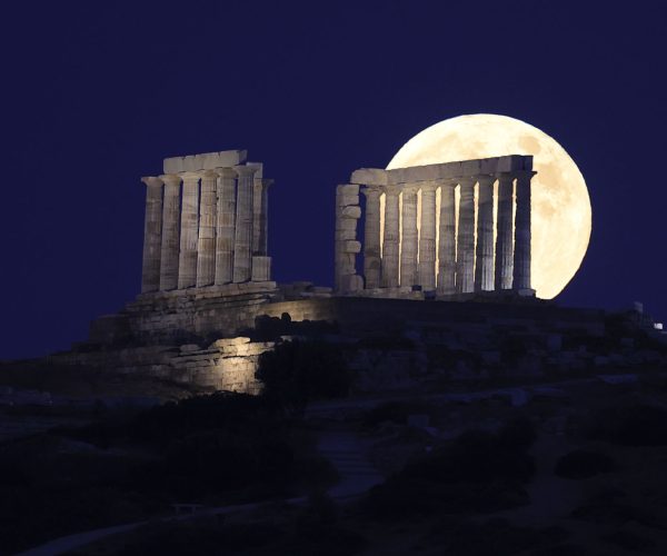Cape Sounio- To Strawberry Moon, ξεπροβάλλει πίσω από τον Ναό του Ποσειδώνα στο Σούνιο. Photo by Ayhan Mehmet/Anadolu Agency via Getty Images
