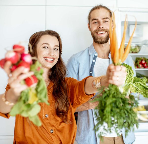 Young couple with healthy food at the kitchen